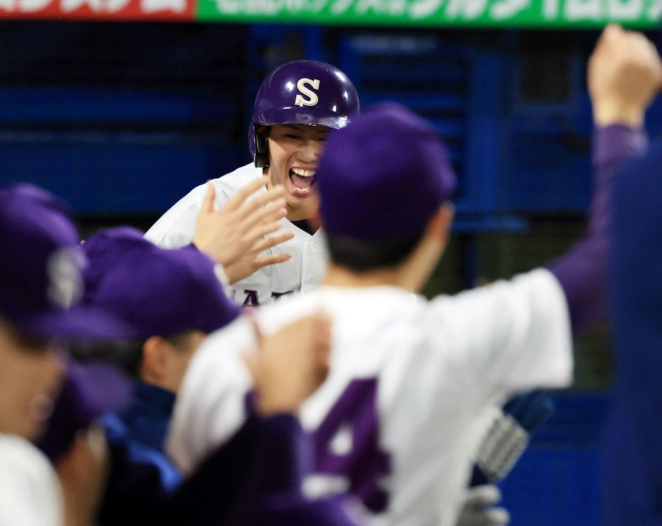 天理大対札幌大　1回裏札幌大無死満塁、佐野の犠飛で生還した伊藤は笑顔でナインとハイタッチ（撮影・浅見桂子）