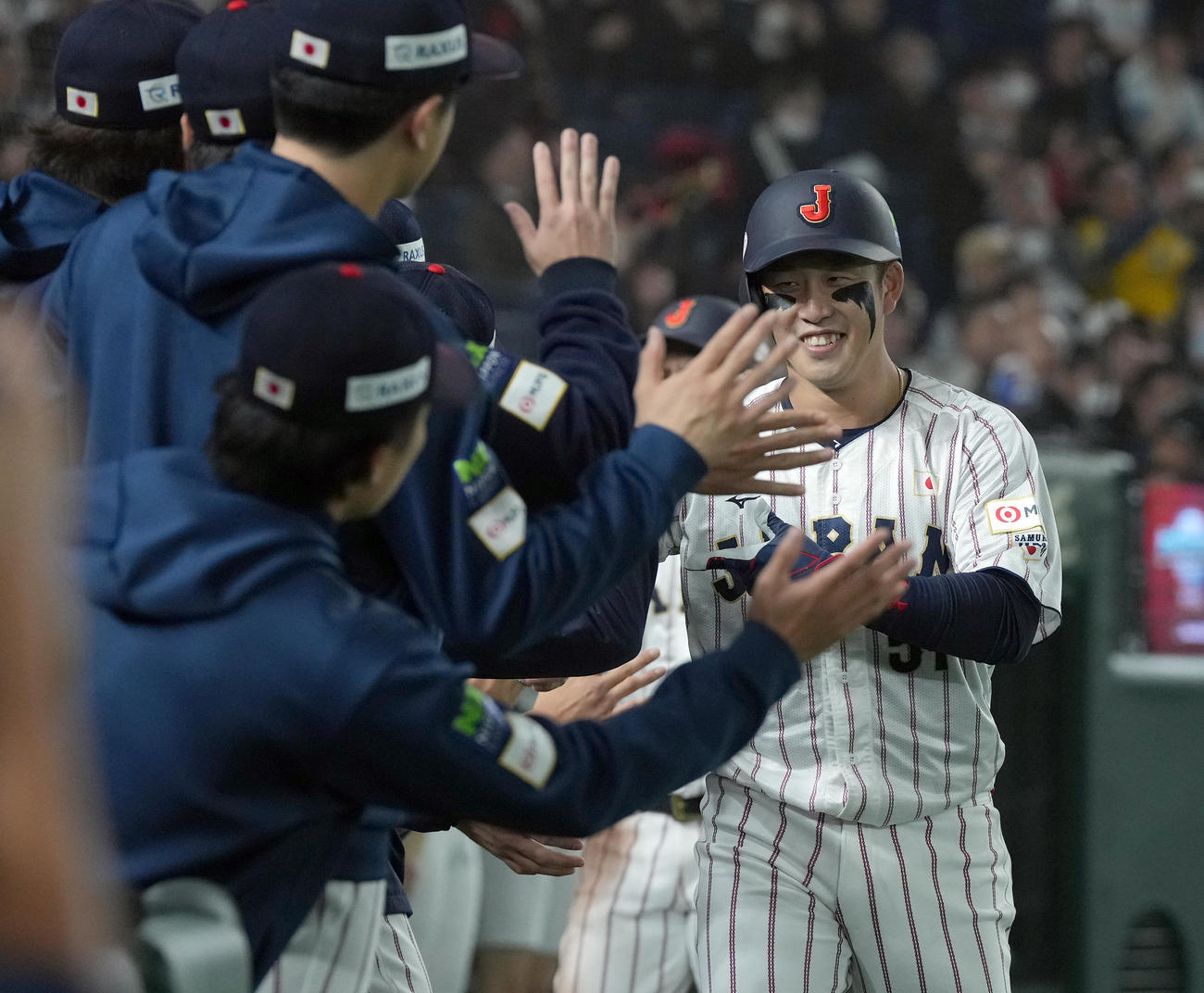 日本対米国　8回裏日本2死一塁、右越えに2点本塁打を放ちナインの祝福を受ける小園（撮影・たえ見朱実）