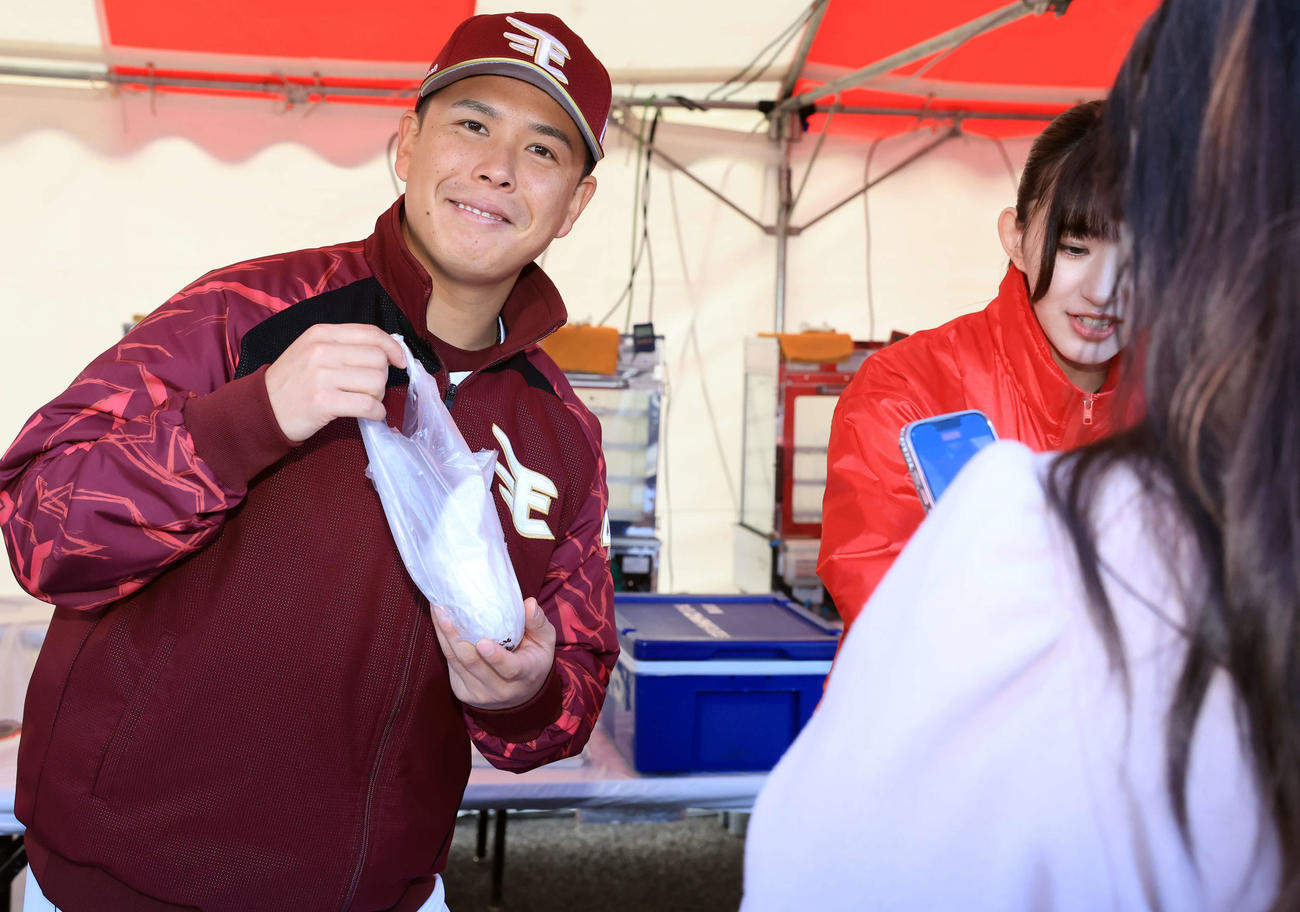 ファンに豚まんを手渡しながらポーズを取る藤井（撮影・浅見桂子）