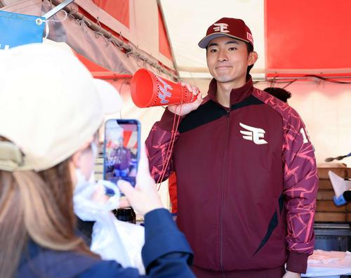 ファンに豚まんを手渡しながらポーズを取る荘司（撮影・浅見桂子）