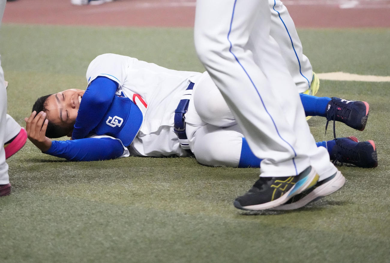 投手チーム対野手チームの試合で本塁打を放ち胴上げ後、転がる中日根尾（撮影・森本幸一）