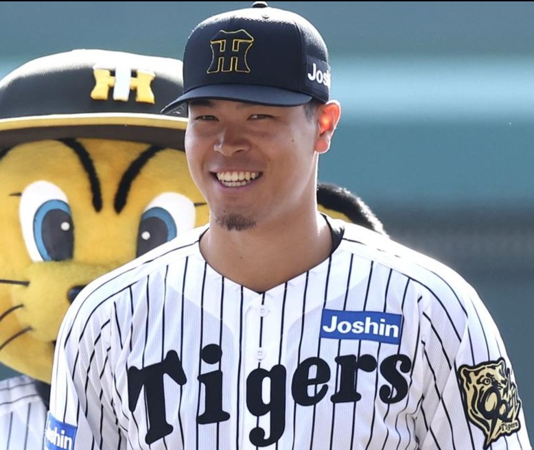 新ユニホームと新キャップを披露し笑顔を見せる佐藤輝明。キャップはシンプルなブラックベースに変更となった（撮影・前田充）