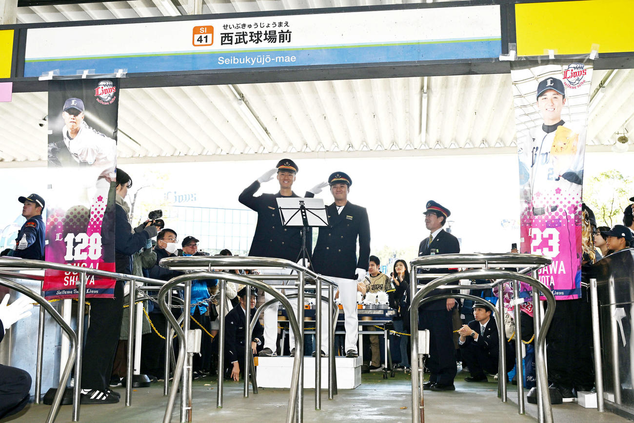 西武球場前駅でファンを迎える西武菅井（左）と糸川（撮影・滝沢徹郎）