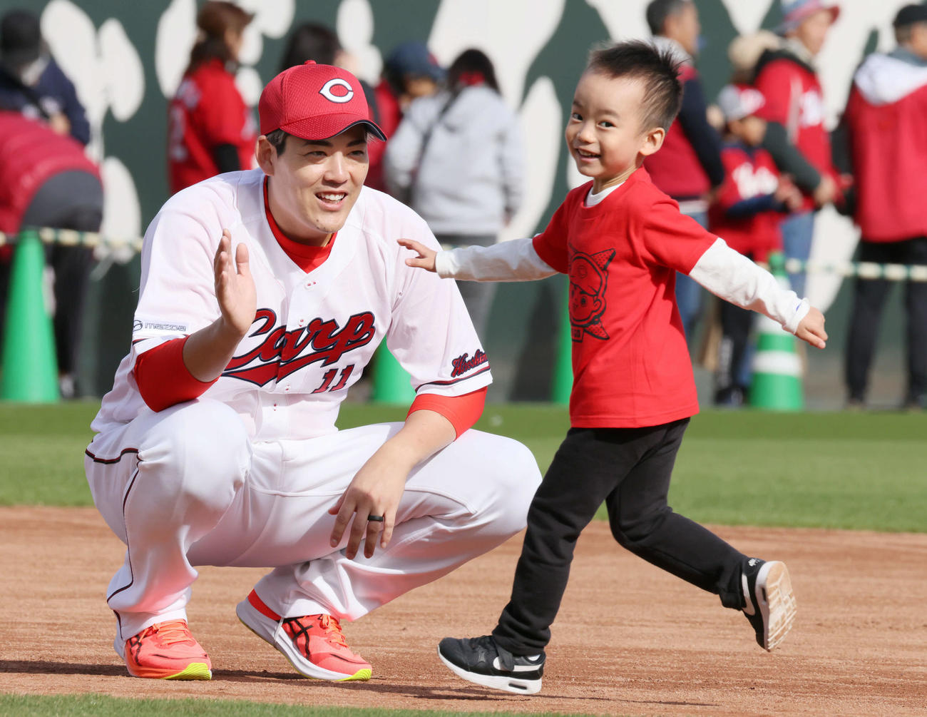 ファン感謝デーでファンとハイタッチする広島九里（撮影・加藤孝規）