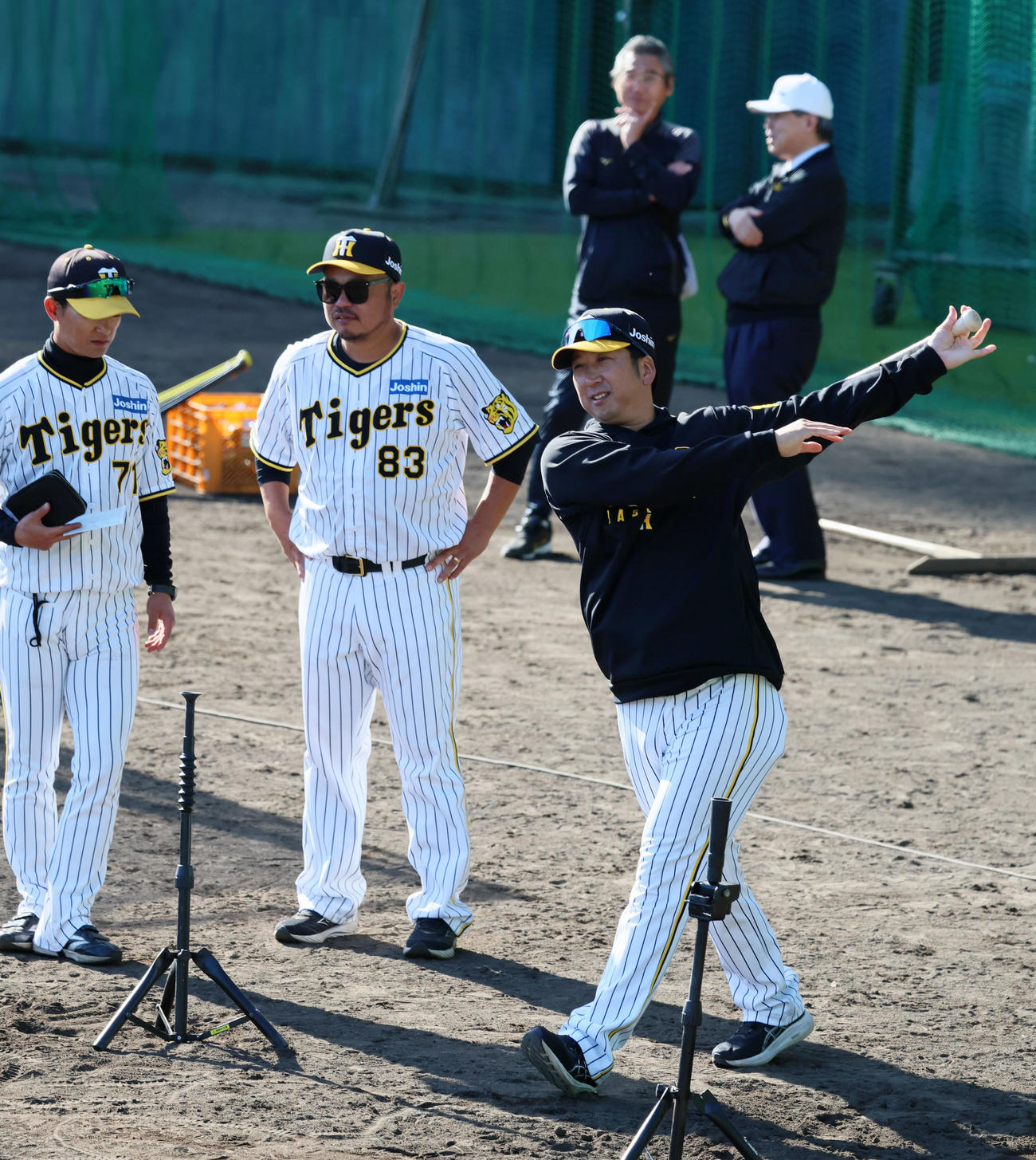 バットを持って素振りする藤川監督。左から上本コーチ、小谷野チーフコーチ。後方右は杉山オーナー（2024年11月7日撮影）