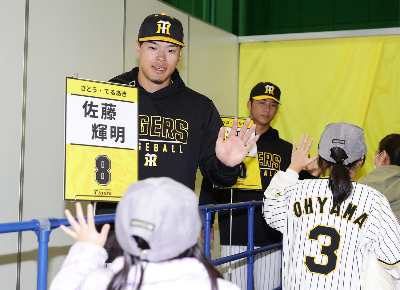 ハイタッチイベントでファンとタッチを交わす阪神佐藤輝（左）と井坪（撮影・前田充）