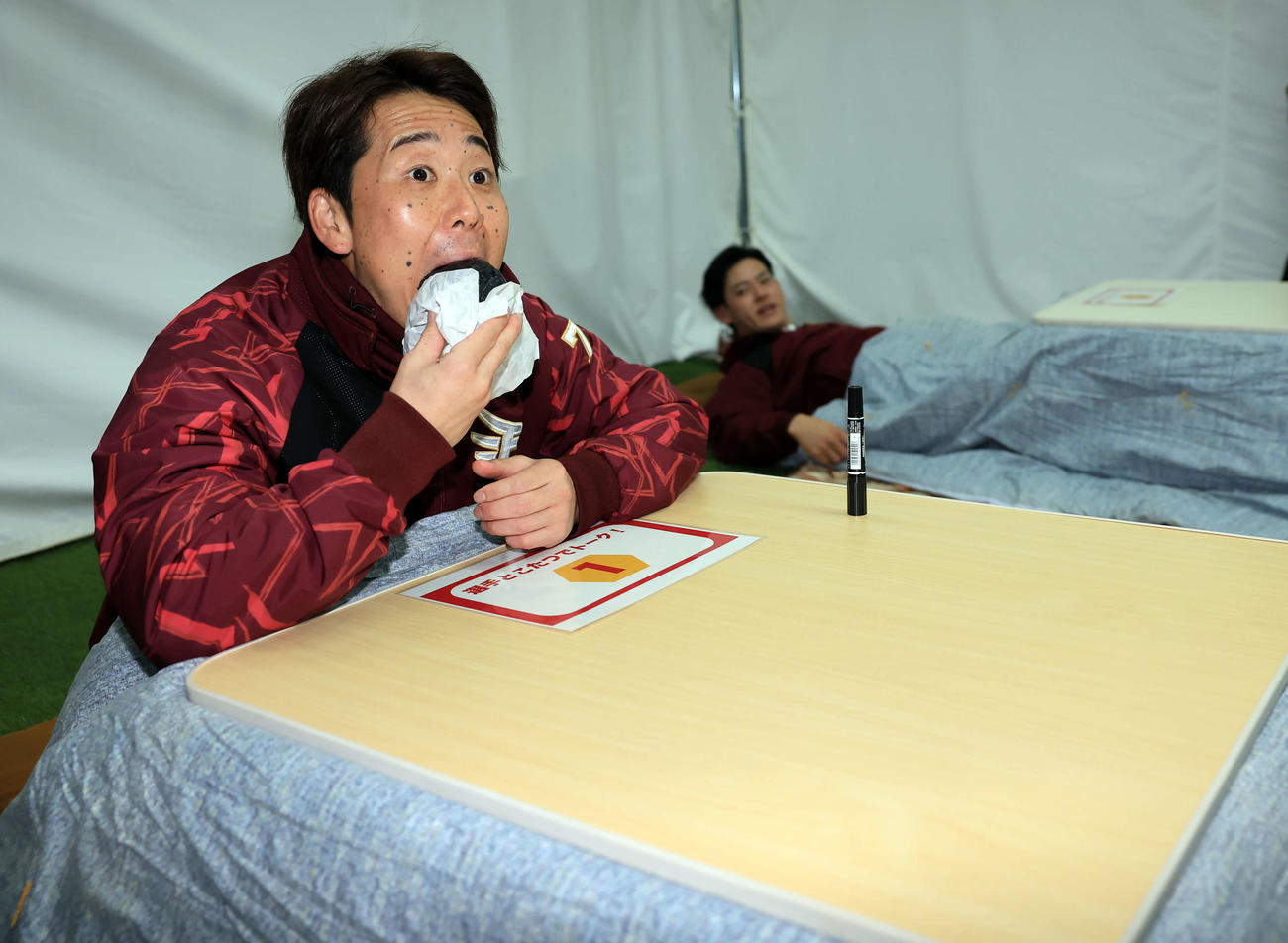 楽天ファン感謝祭で、「こたつトーク」でファンを待つ間、まんじゅうにかぶりつく鈴木大（左）。奥は伊藤裕（撮影・浅見桂子）