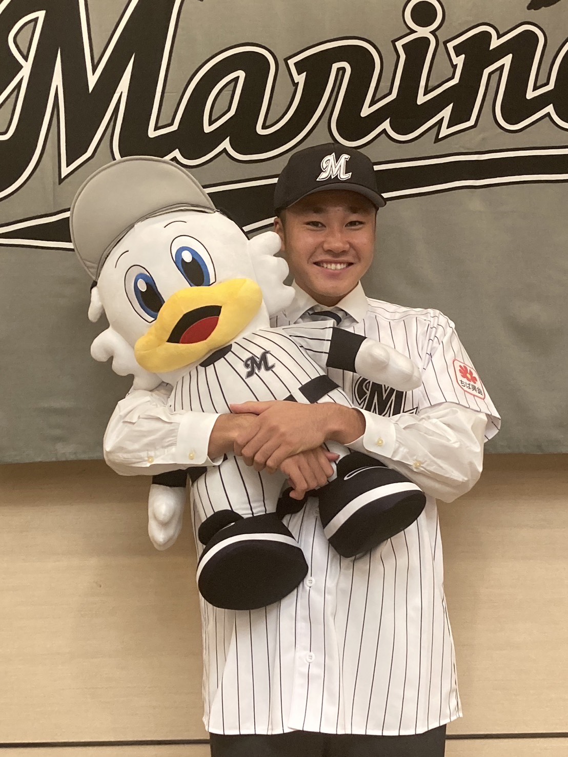 マーくんを抱え笑顔のドラフト5位・広池（球団提供）