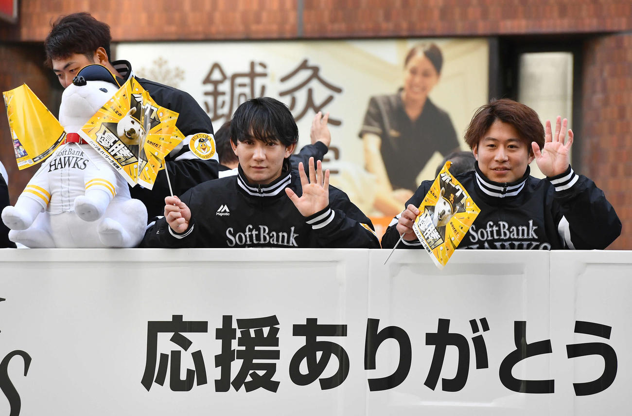 リーグ優勝祝賀パレードでバスの上からファンに手を振る正木（左から2人目）と川村（撮影・岩下翔太）