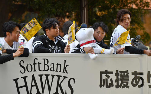 リーグ優勝祝賀パレードでバスの上から旗を振る、左から沢柳、村田、前田悠、大山（撮影・岩下翔太）