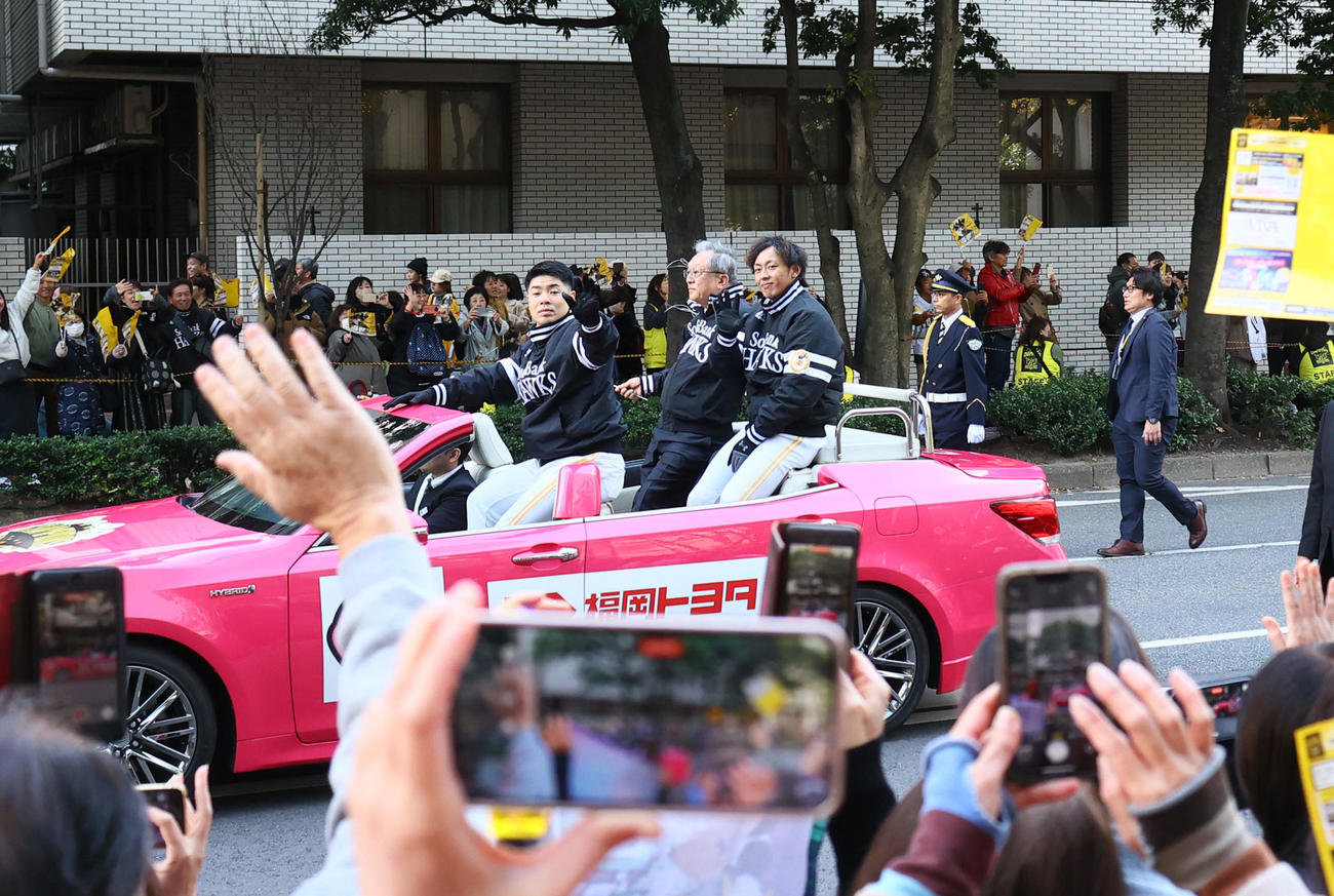 リーグ優勝パレードで沿道のファンに手を振る近藤（左）と今宮（撮影・鬼束羽瑠菜）
