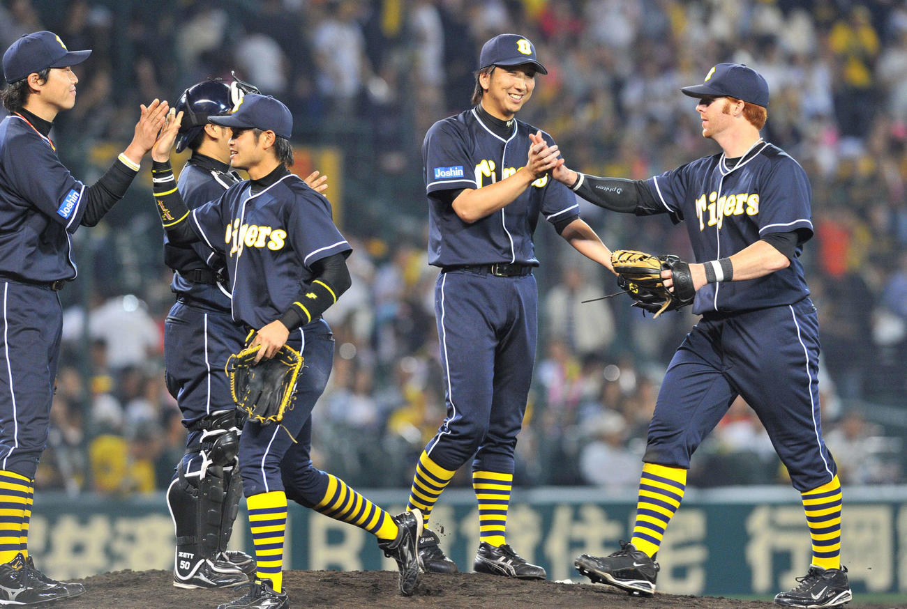 11年6月、日本ハムとの交流戦に勝利し、阪神マートン（右）らとタッチする藤川（中央）ら