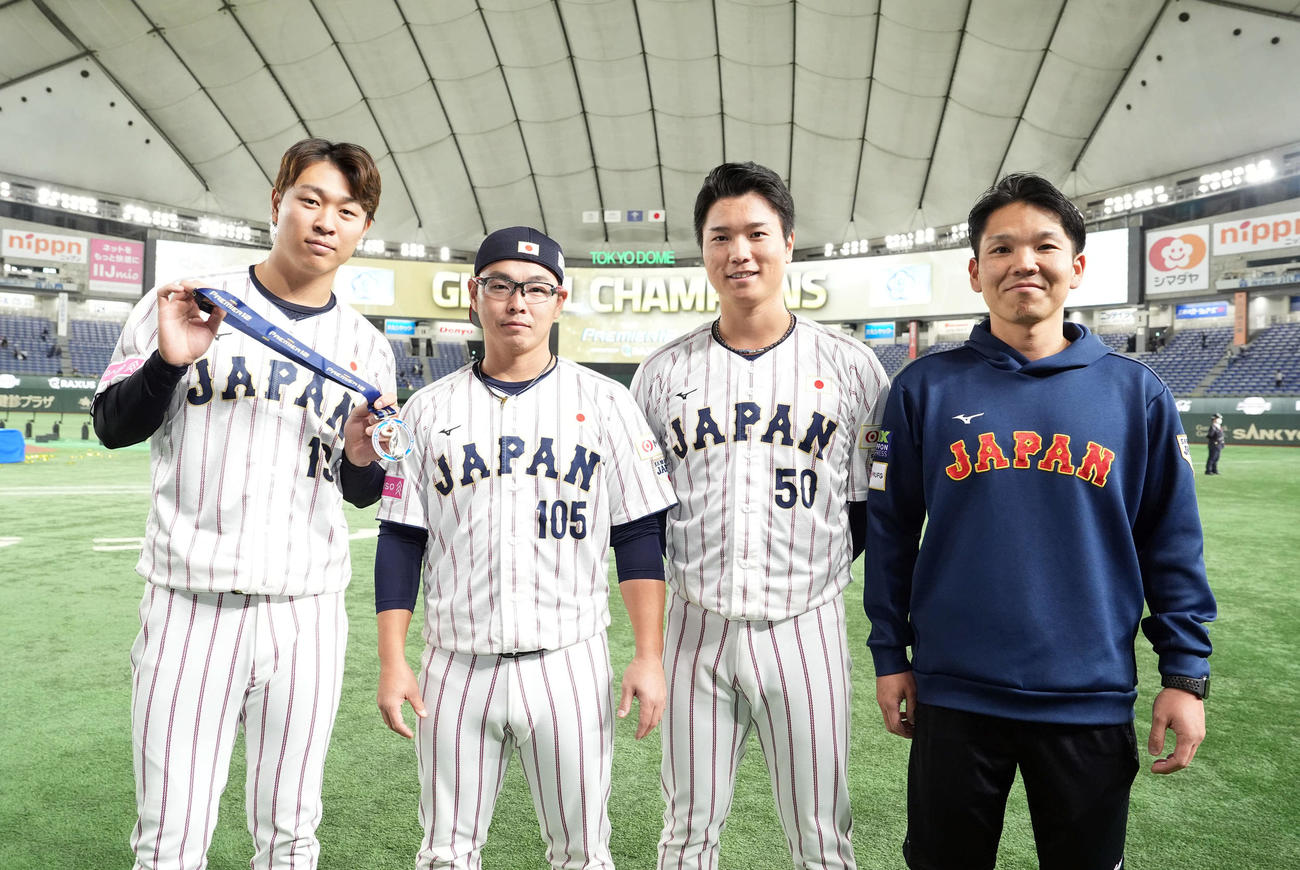 日本対台湾　記念撮影に納まる中日勢。左から高橋宏、杉山ブルペン捕手、清水、水谷トレーナー（撮影・たえ見朱実）