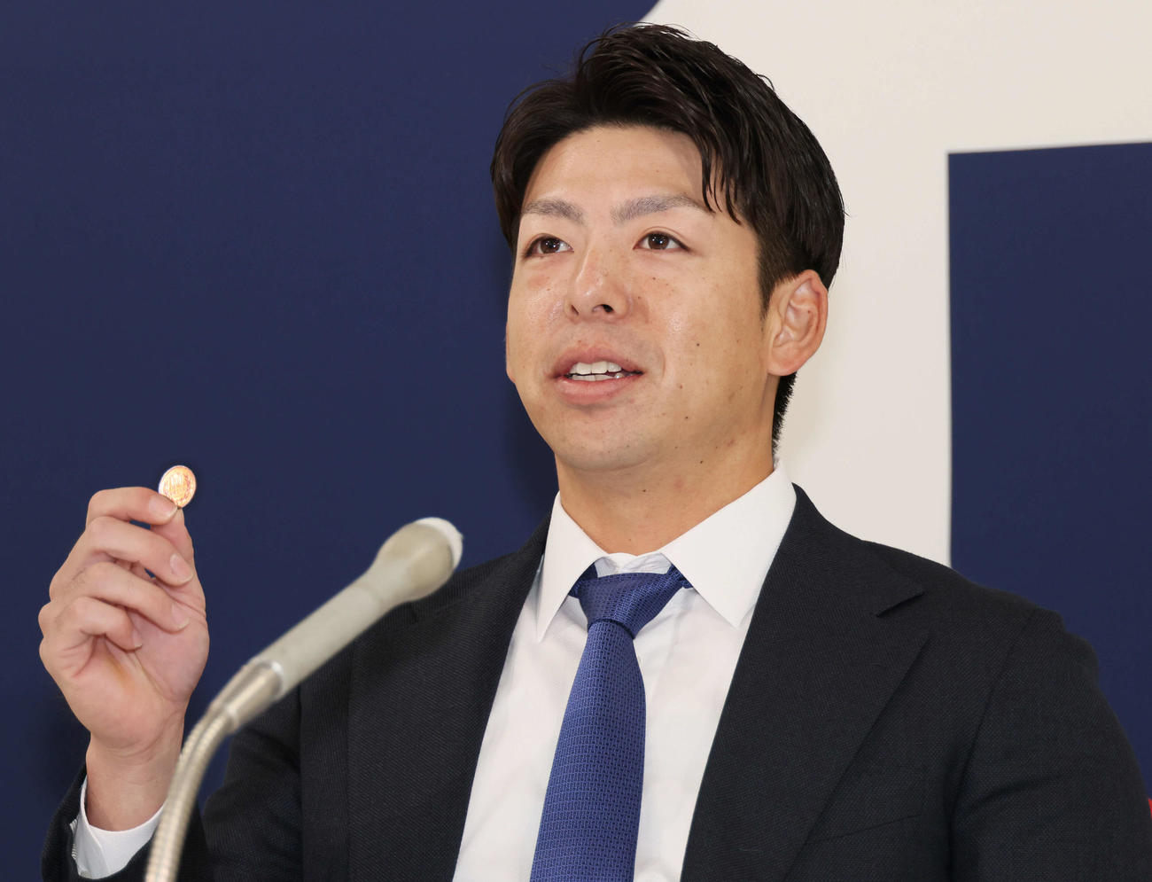 契約更改後の会見で、10円玉を見せる広島野間（撮影・加藤孝規）