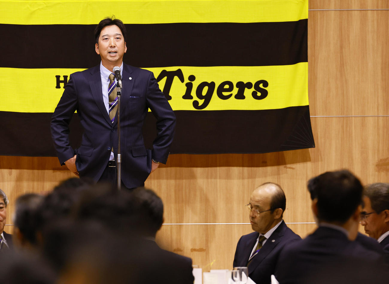 球団納会であいさつする阪神藤川監督。右下は岡田オーナー付顧問（撮影・藤尾明華）