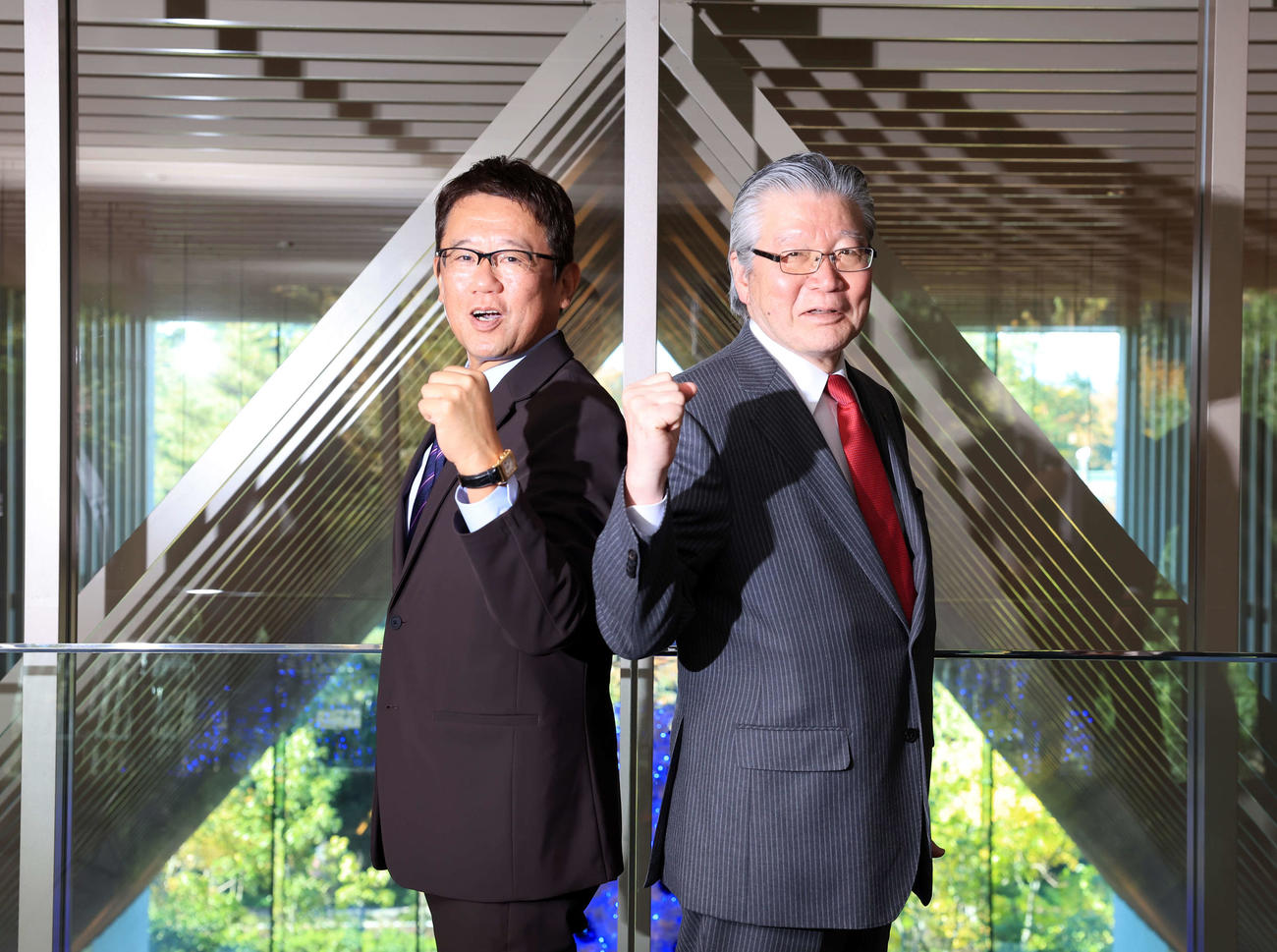 立川「SORANO HOTEL」で、笑顔でガッツポーズする立飛の村山正道社長（右）と古田敦也理事長（撮影・浅見桂子）