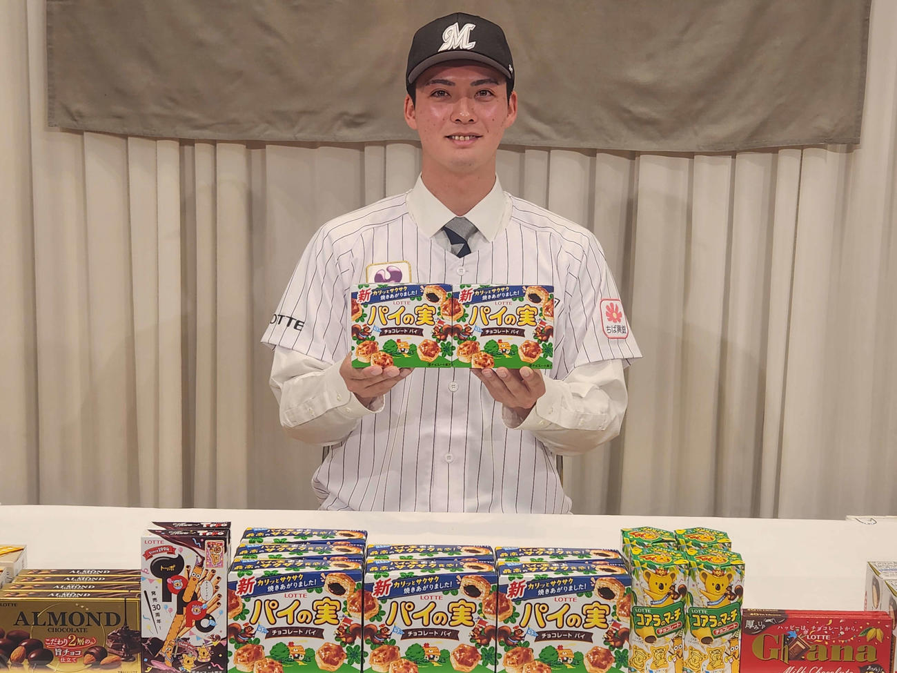 仮契約を終え、ロッテのお菓子「パイの実」を手に笑顔を見せるロッテ2位の東洋大・一條（撮影・保坂淑子）
