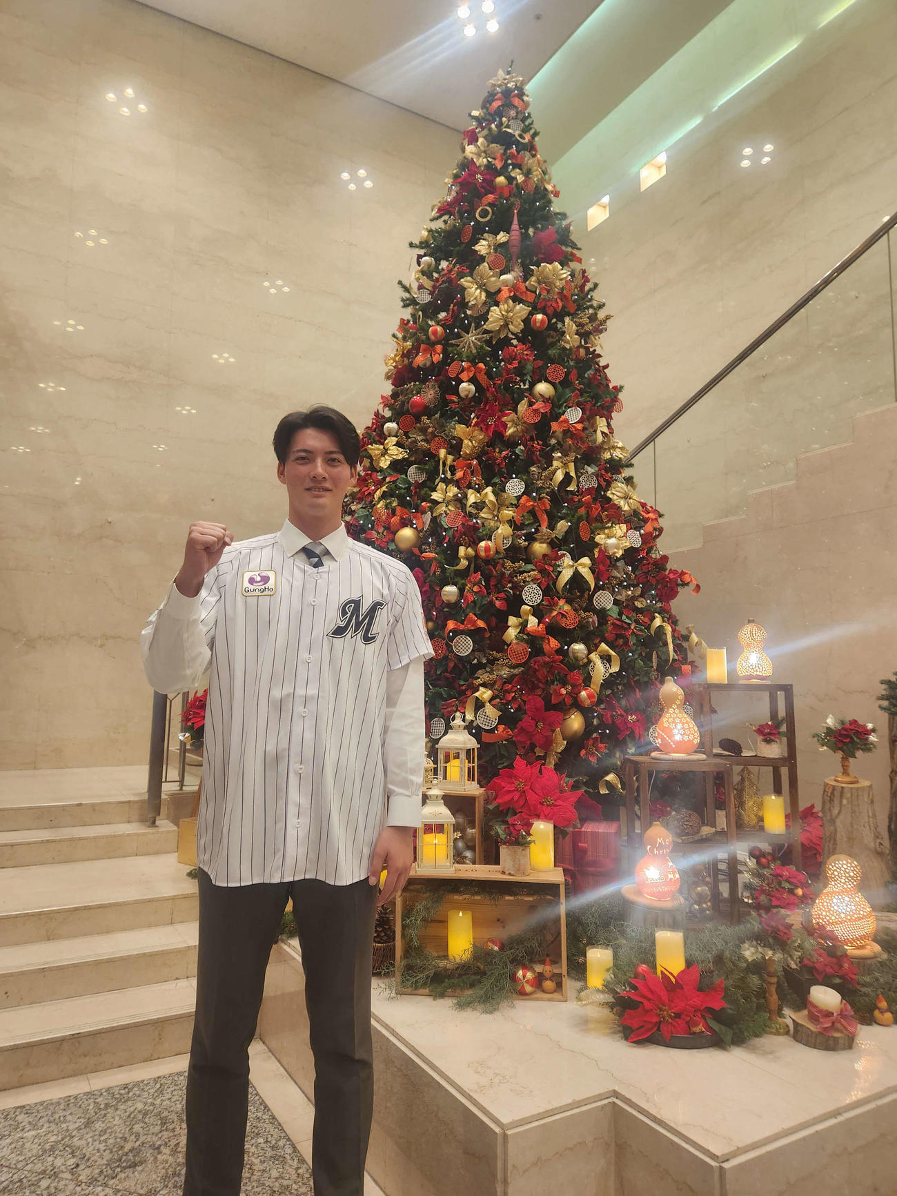 仮契約を終え、川越プリンスホテルのクリスマスツリーの前でガッツポーズを見せるロッテ2位の東洋大・一條（撮影・保坂淑子）