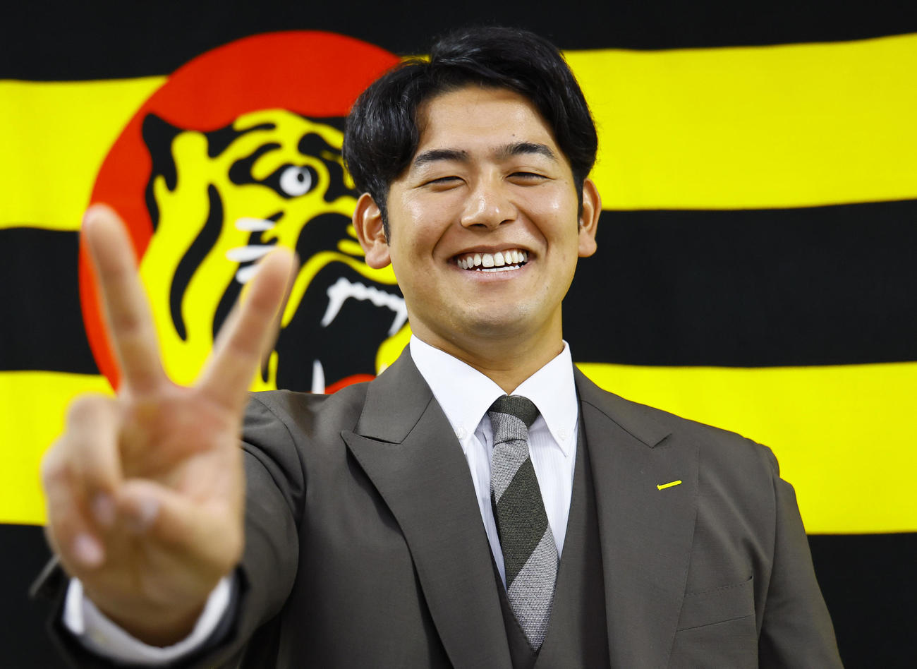 契約更改を終え、笑顔でポーズをとる阪神岡留（撮影・藤尾明華）