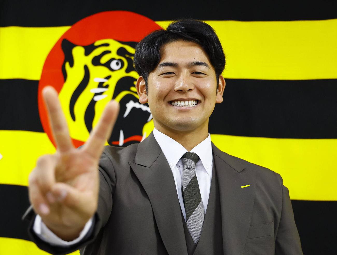 契約更改を終え、笑顔でポーズをとる阪神岡留（撮影・藤尾明華）