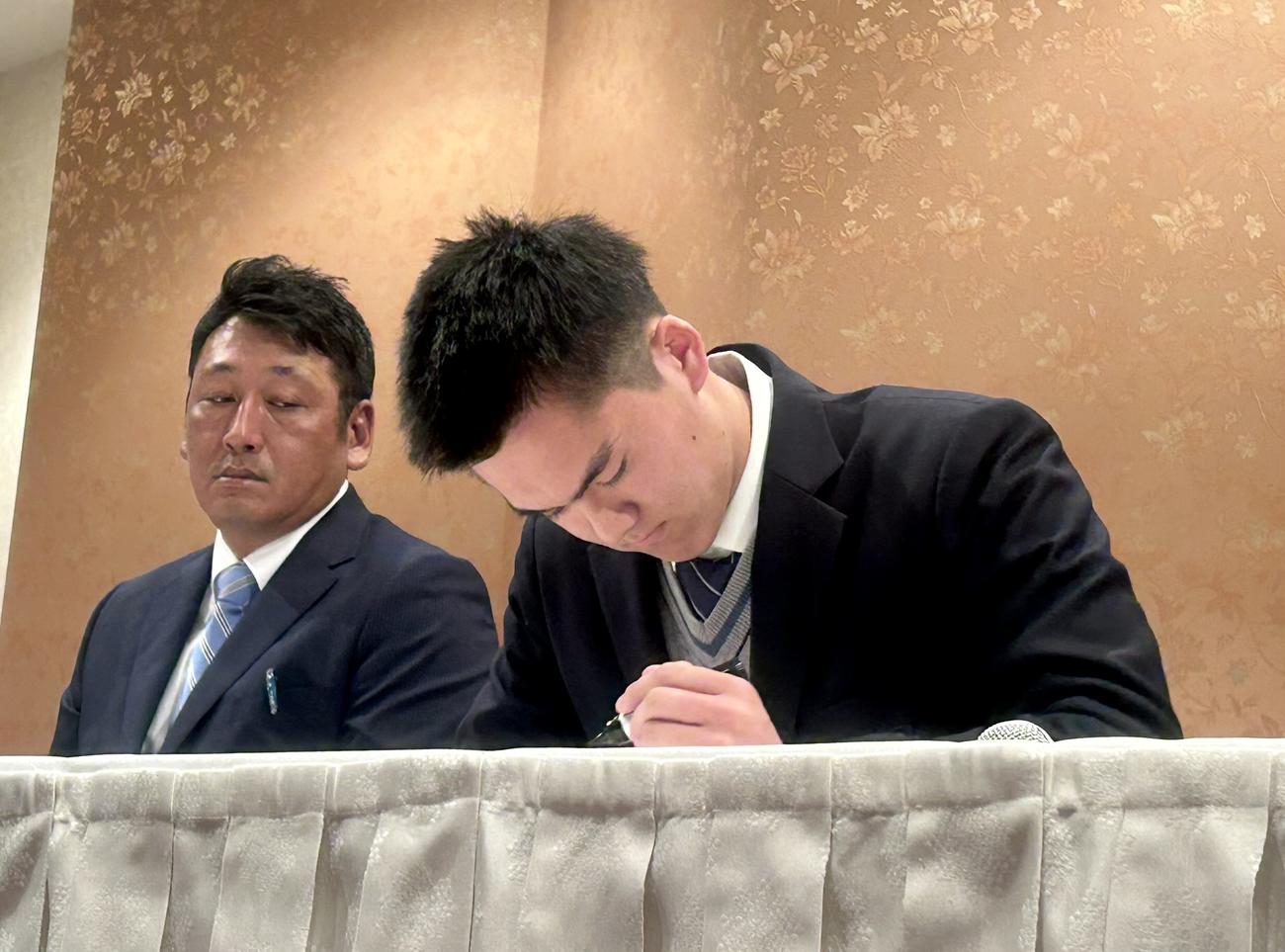 色紙に「謙虚」と書き込む人日本ハムドラフト2位の東海大相模・藤田、左は同校の原監督（撮影・黒須亮）