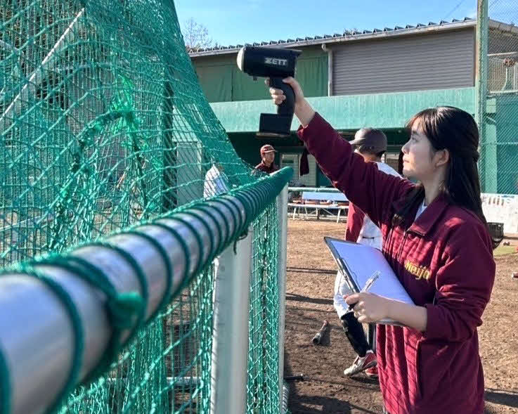 スピードガンを用いて、投手の球速を計測する名城大・吉田マネジャー