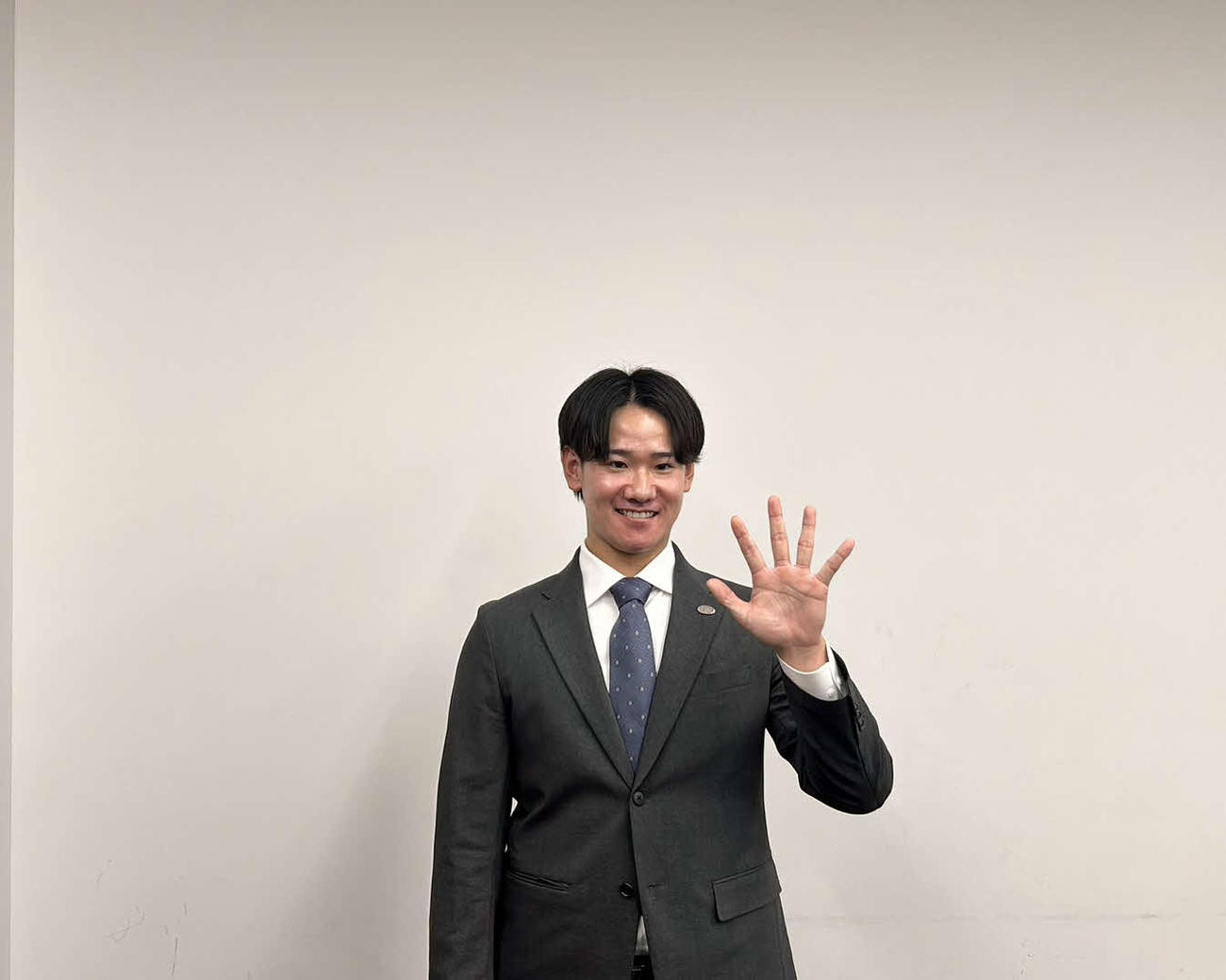 契約更改交渉後の会見で報道陣のリクエストにこたえ、5のポーズをする巨人井上（撮影・上田悠太）