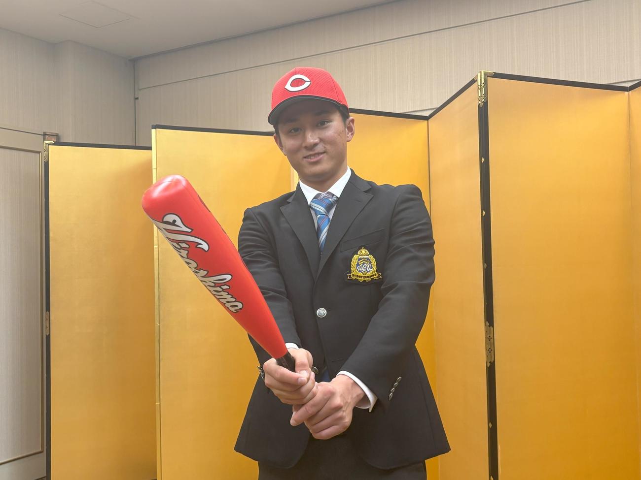仮契約を終えてカメラマンの要望に応えてポーズをとる広島ドラフト1位の青学大・佐々木泰内野手（写真右）左は高山健一担当スカウト（撮影・前原淳）＝2024年11月28日、都内ホテル