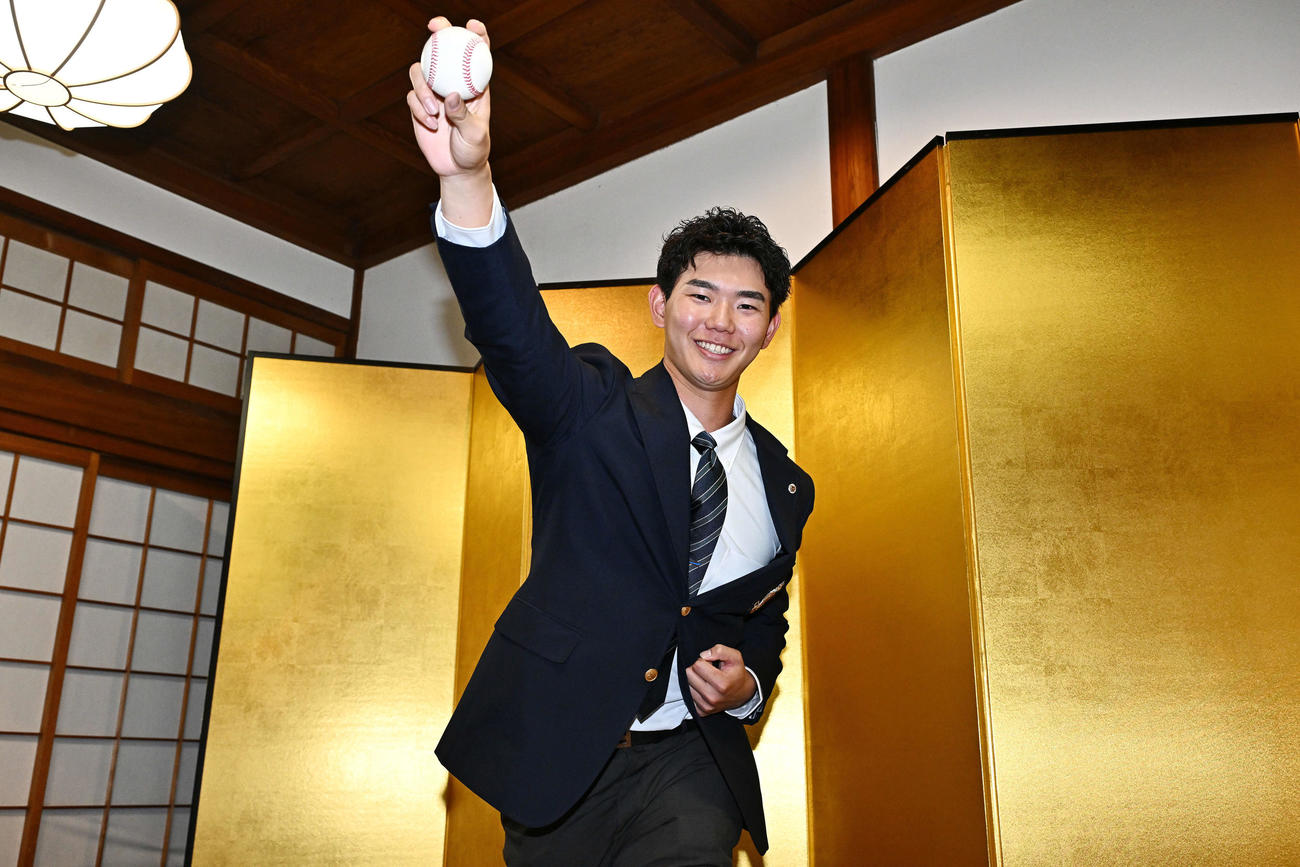 大国魂神社で仮契約を行った日本ハムドラフト3位の明大・浅利は金びょうぶの前でシャドーピッチングをする（撮影・滝沢徹郎）