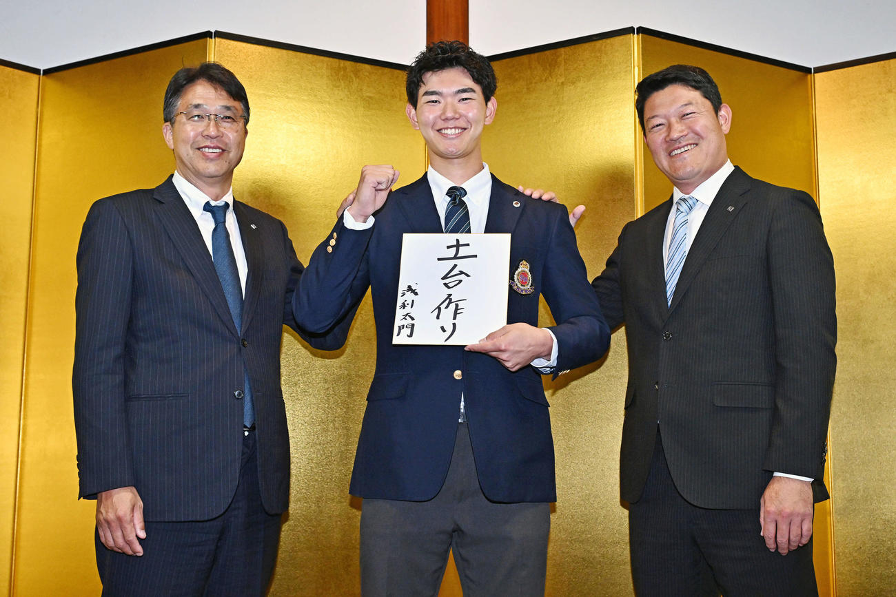 大国魂神社で仮契約を行った日本ハムドラフト3位の明大・浅利（中央）は金びょうぶの前で大渕スカウト部長（左）、山本スカウトと写真に納まる（撮影・滝沢徹郎）