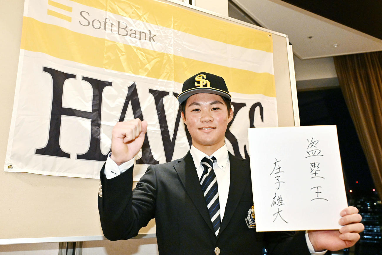 仮契約を終えたソフトバンクドラフト2位神奈川大・庄子は「盗塁王」と記した色紙を手にガッツポーズする（撮影・滝沢徹郎）