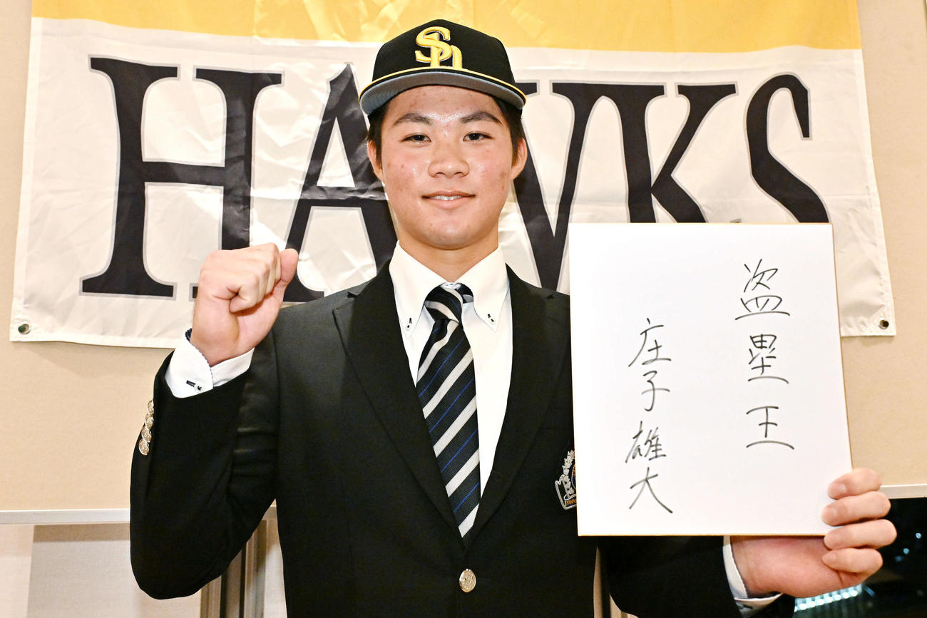 仮契約を終えたソフトバンクドラフト2位神奈川大・庄子は「盗塁王」と記した色紙を手にガッツポーズする（撮影・滝沢徹郎）