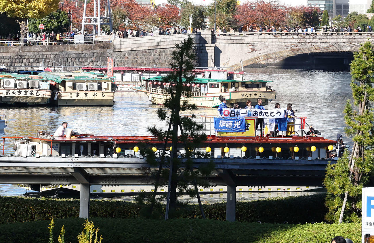 屋形船で「日本一　おめでとう」の横断幕を手にパレードを見るファン（撮影・鈴木正人）