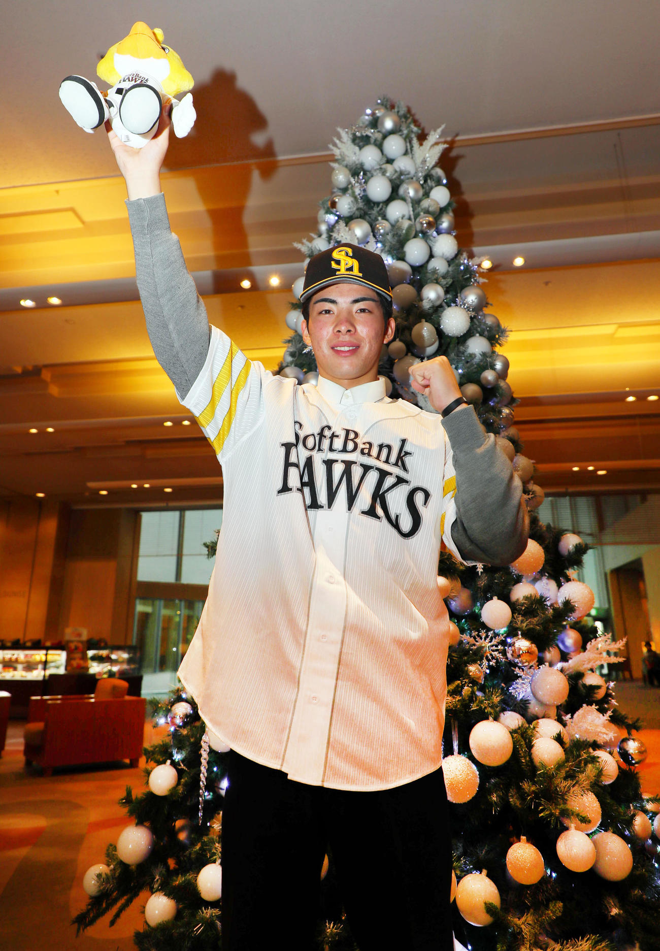 ソフトバンクと仮契約を結んだドラフト1位の村上は、クリスマスツリーの前でガッツポーズ（撮影・宮崎幸一）