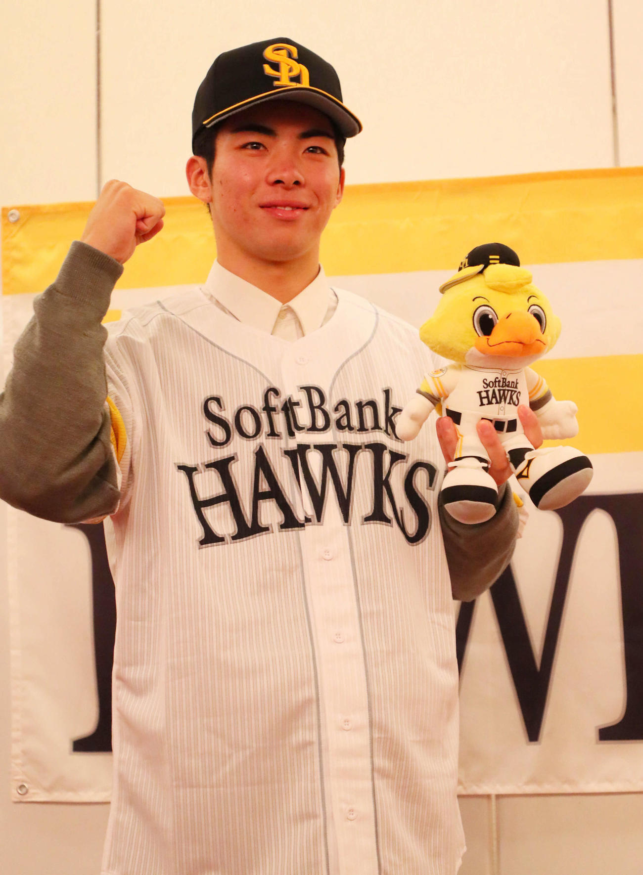 ソフトバンクと仮契約を結んだドラフト1位の村上は、球団旗の前でガッツポーズ（撮影・宮崎幸一）