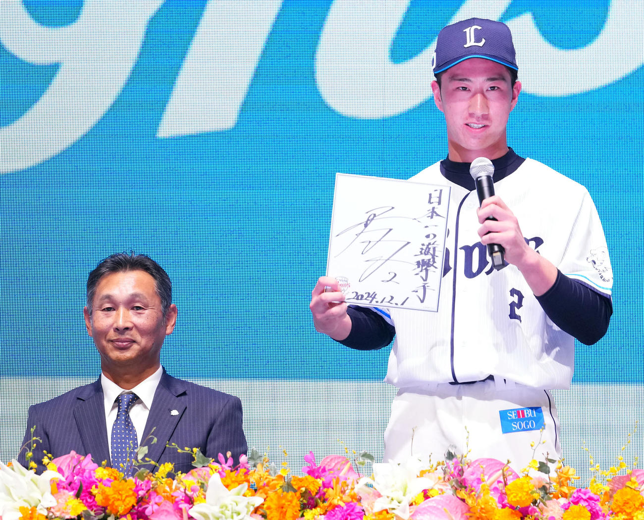新入団選手発表会で色紙へ目標を記した西武斎藤。左は西口監督（撮影・横山健太）