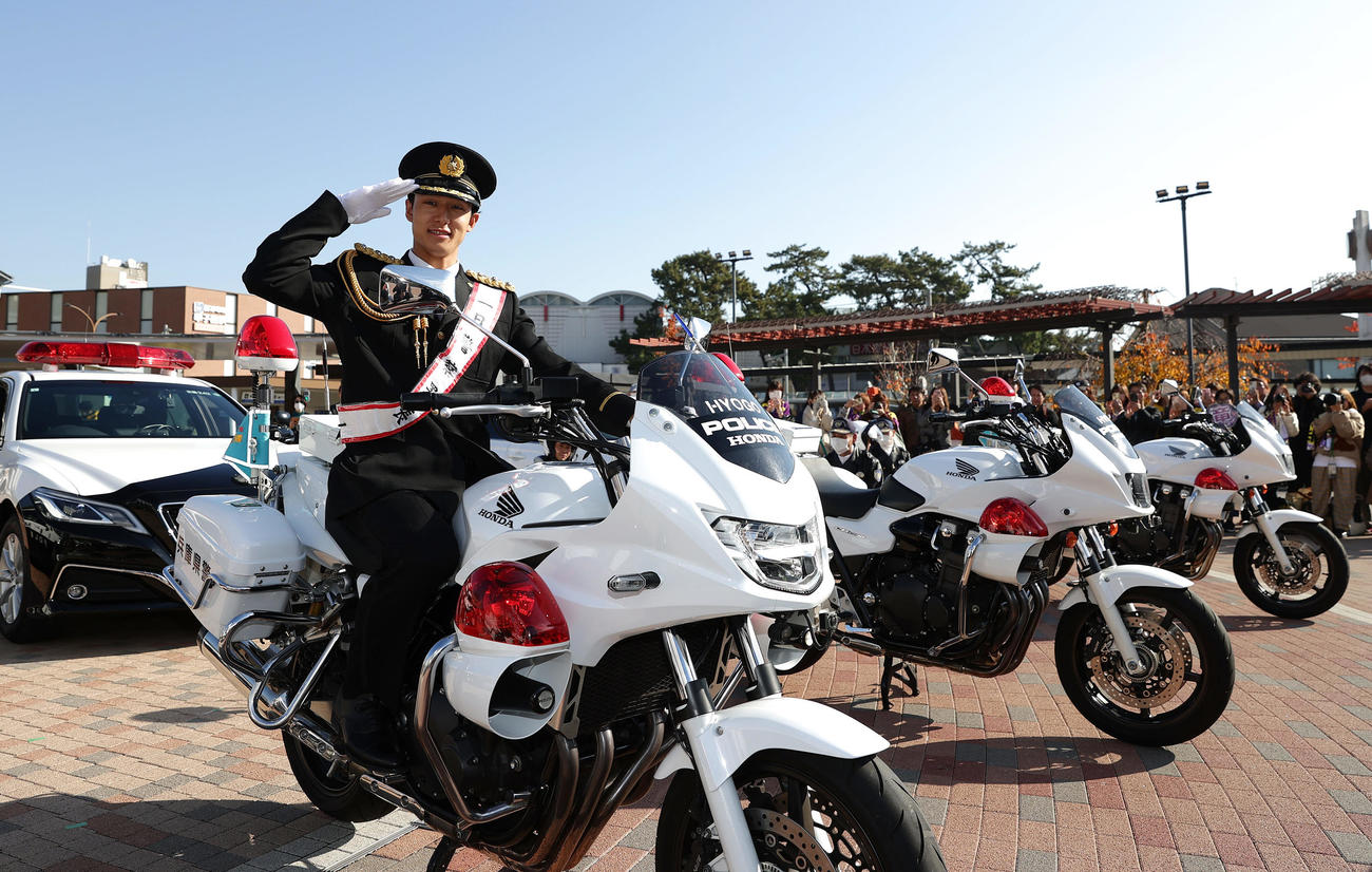 甲子園警察署の一日署長を務め、白バイにまたがり敬礼する阪神小幡（撮影・前田充）
