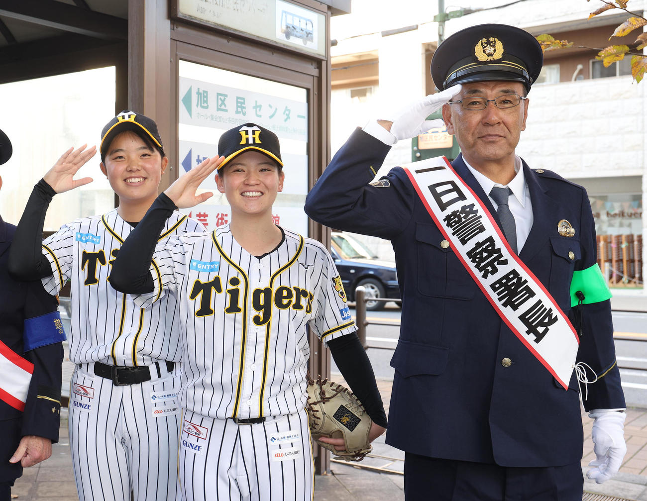 敬礼する左から、阪神タイガースWomen樫谷、安藤、一日警察署長の木戸監督（撮影・白石智彦）