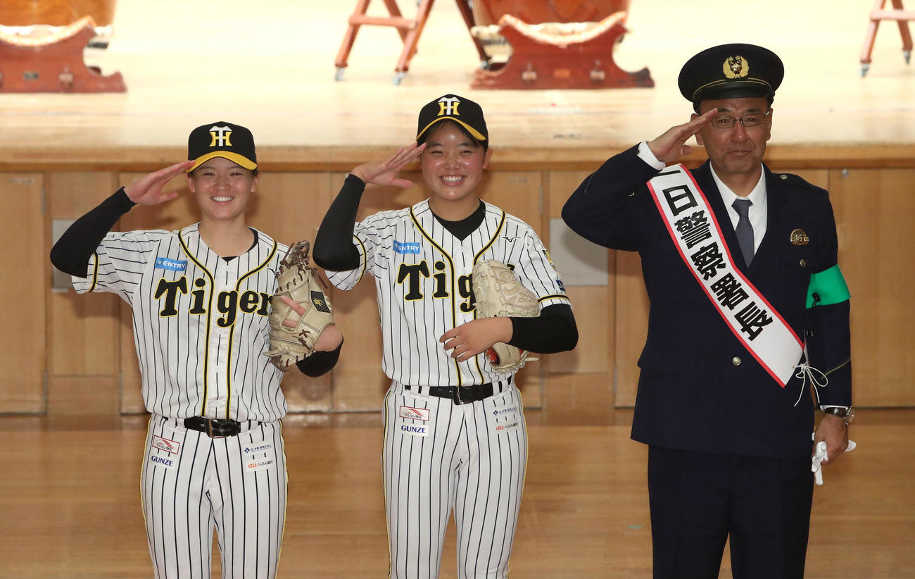 敬礼する左から、阪神タイガースWomen安藤、樫谷、一日警察署長の木戸監督（撮影・白石智彦）