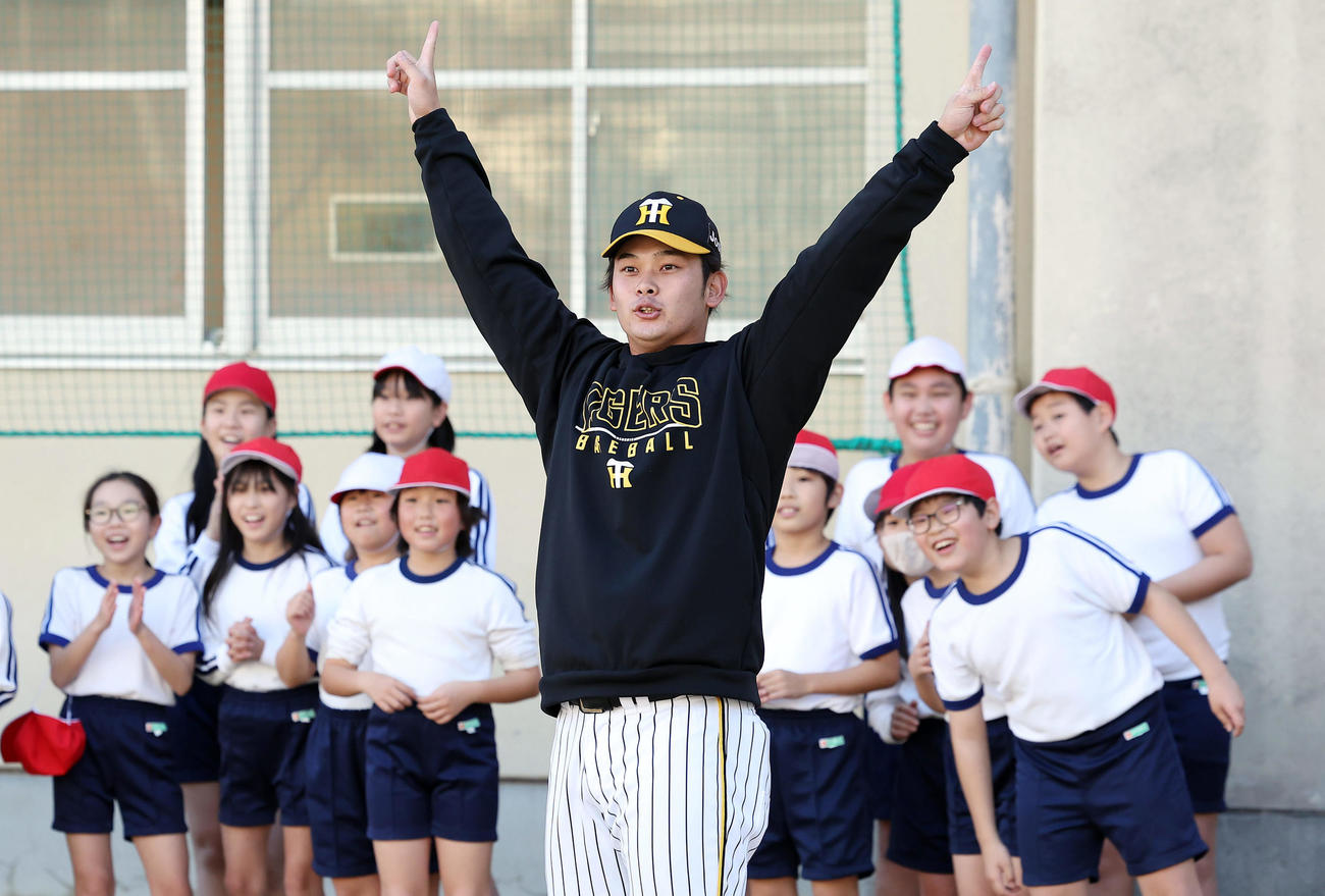 ゲストティーチャーで小学校を訪れ子どもたちに打撃を披露し、ポーズを決める阪神野口（撮影・前田充）