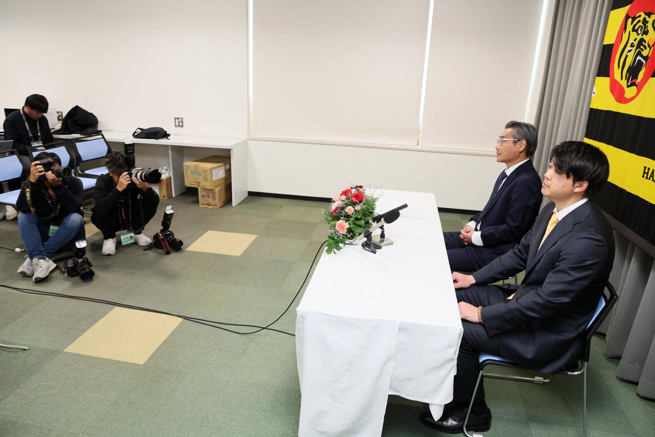入団会見を行った楠本。左は嶌村球団本部長（撮影・加藤哉）