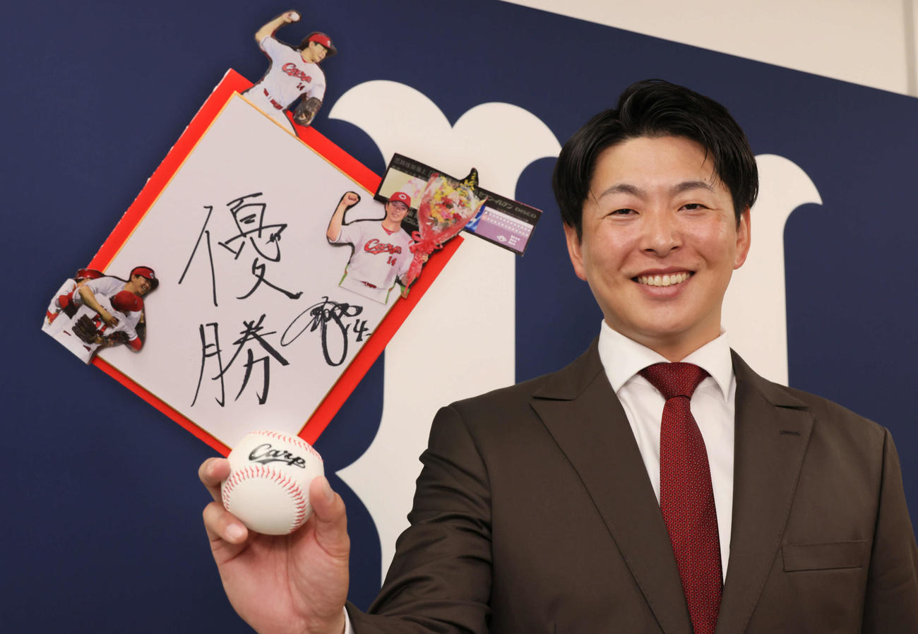 契約更改後、来季の目標「優勝」と書いた色紙を手に笑顔を見せる広島大瀬良（撮影・加藤孝規）