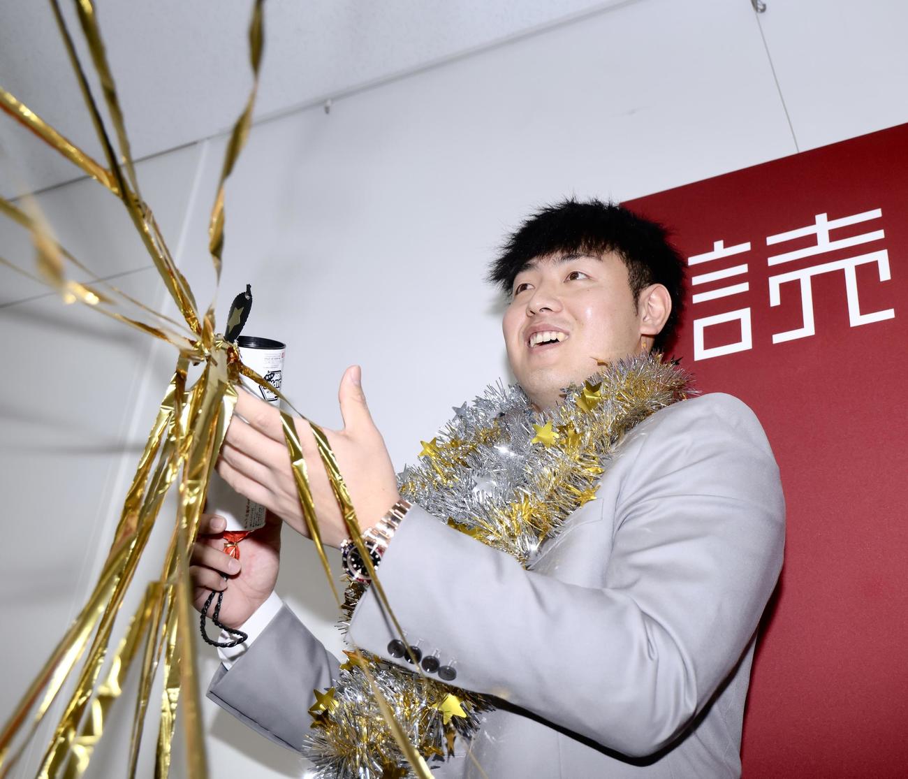契約更改を終え、明るい表情でクラッカーを鳴らす巨人岡本和（撮影・河田真司）