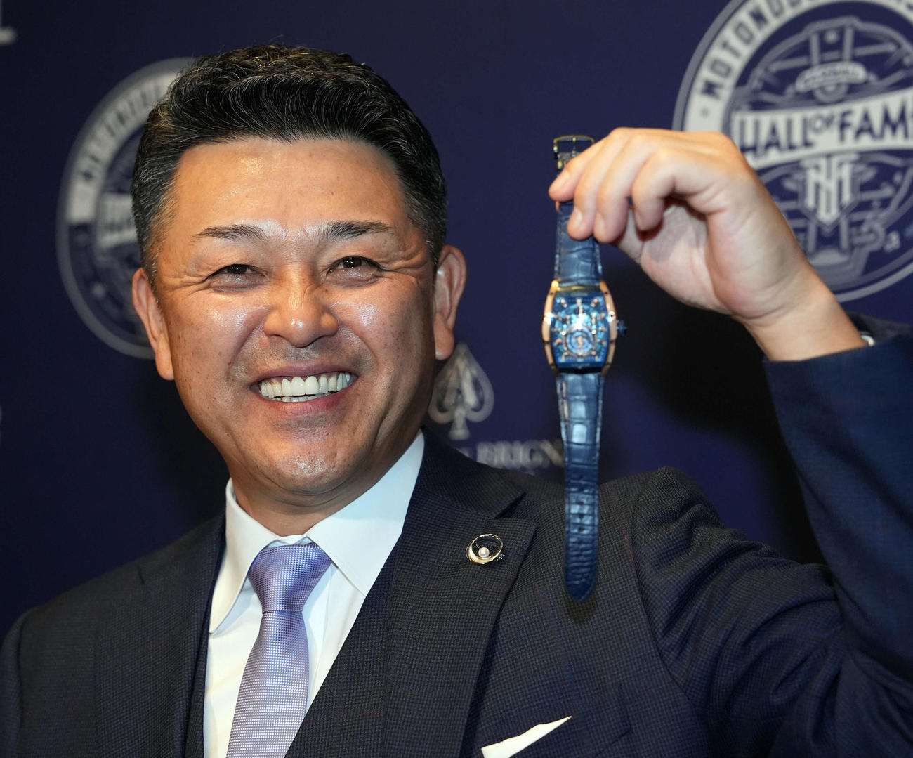 記念品に贈られた世界に1つだけの高級時計を手に笑顔を見せる谷繁氏（撮影・たえ見朱実）
