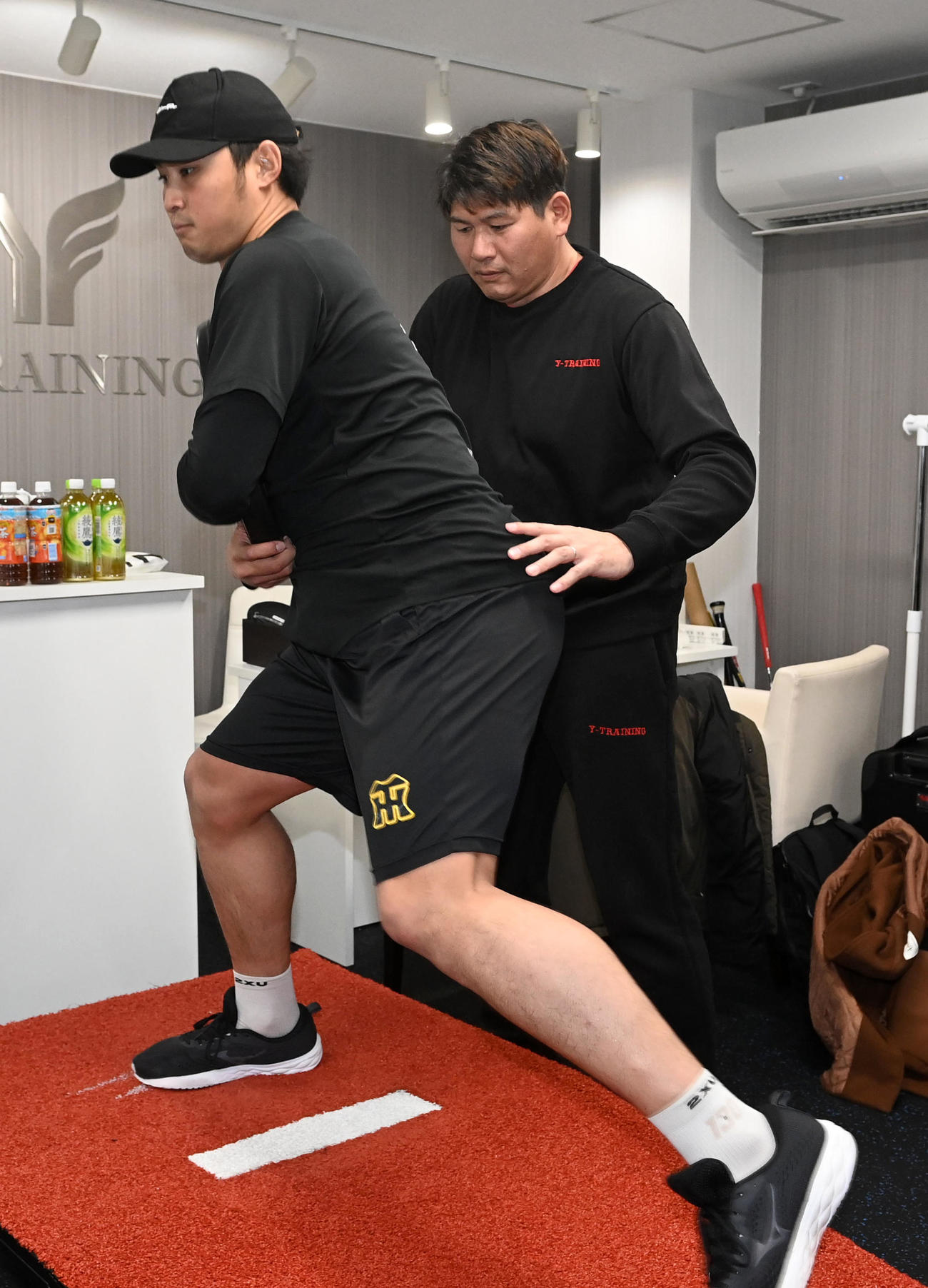 村上幸史指導責任者（右）の元、投てき動作を行う佐藤蓮（撮影・前岡正明）