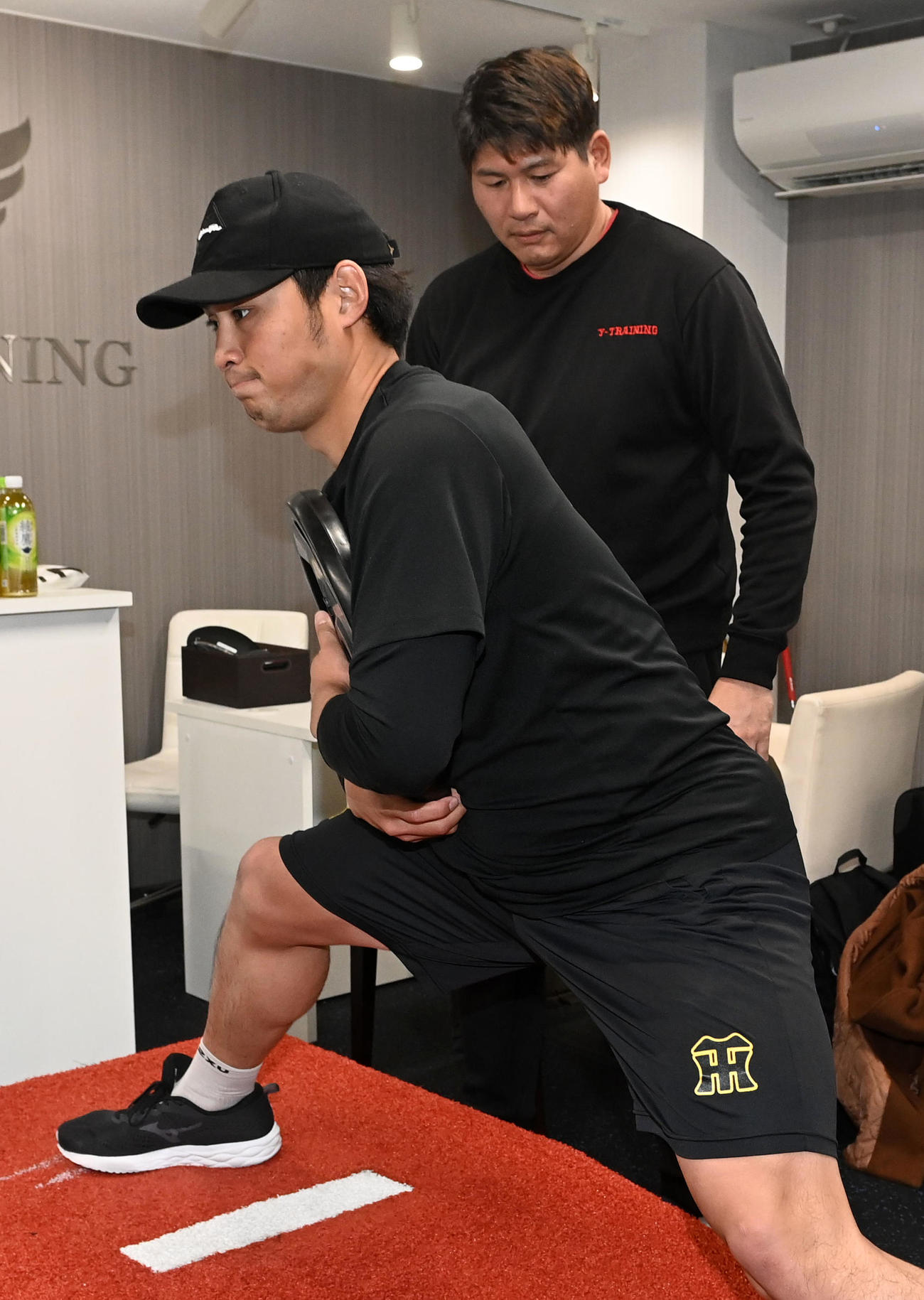 村上幸史指導責任者（右）の元、投てき動作を行う佐藤蓮（撮影・前岡正明）