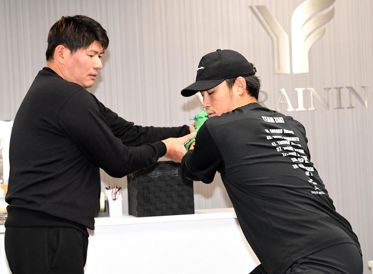 投てき動作で村上幸史指導責任者（左）の指導を受ける佐藤蓮（撮影・前岡正明）