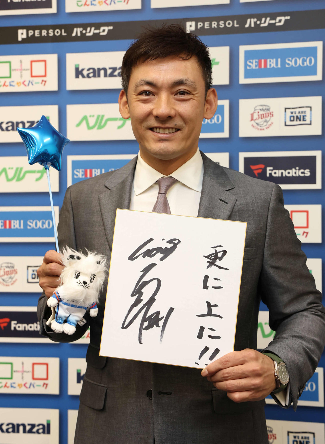 プロ24年目を迎える来季、「更に上に」と記した色紙を手に写真に納まる西武栗山（撮影・丹羽敏通）