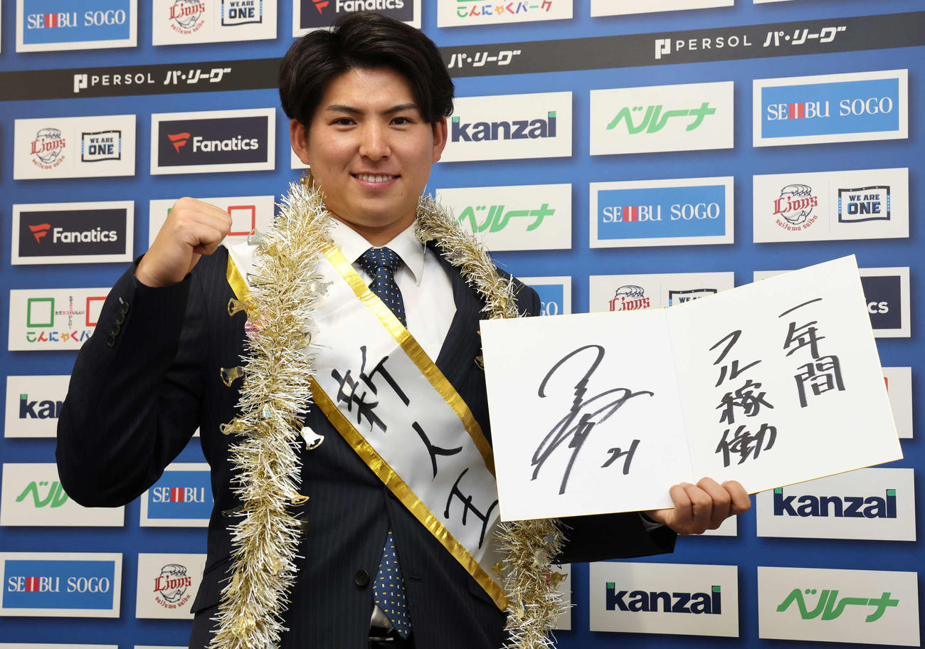 「一年間フル稼働」と、来季の目標を記した色紙を手にポーズを決める西武武内（撮影・丹羽敏通）