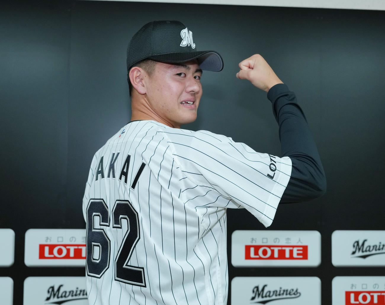 ロッテ新入団選手発表会で背番号62のユニホーム姿を披露する坂井（撮影・菅敏）